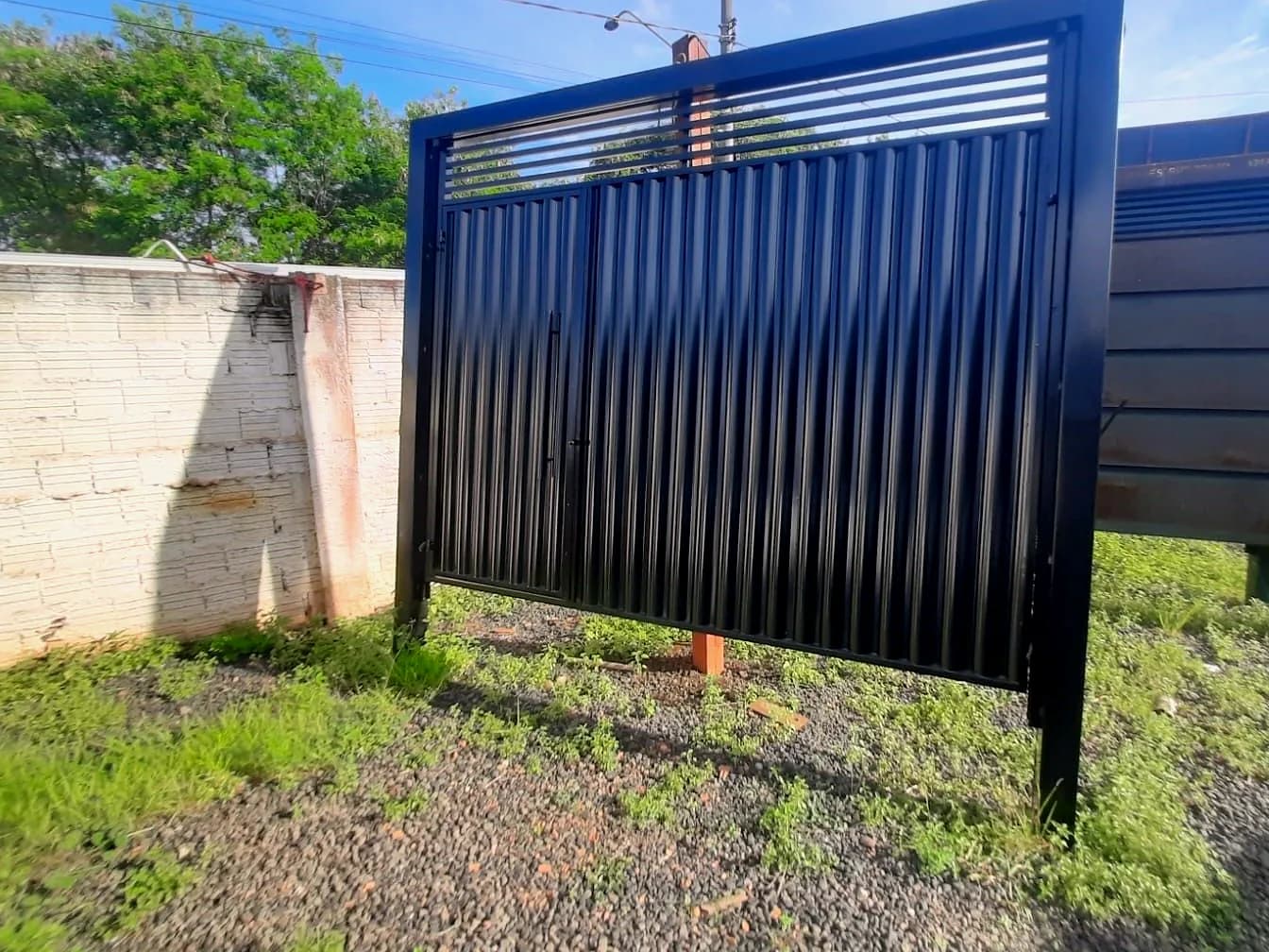 Portão basculante preto com frisos e porta social embutida